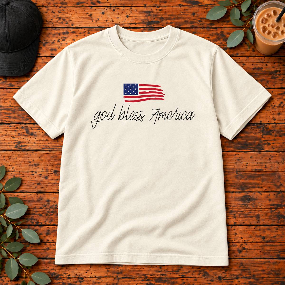God Bless America Script on Comfort Colors Adult Tee — Ivory — single garment on rustic wood