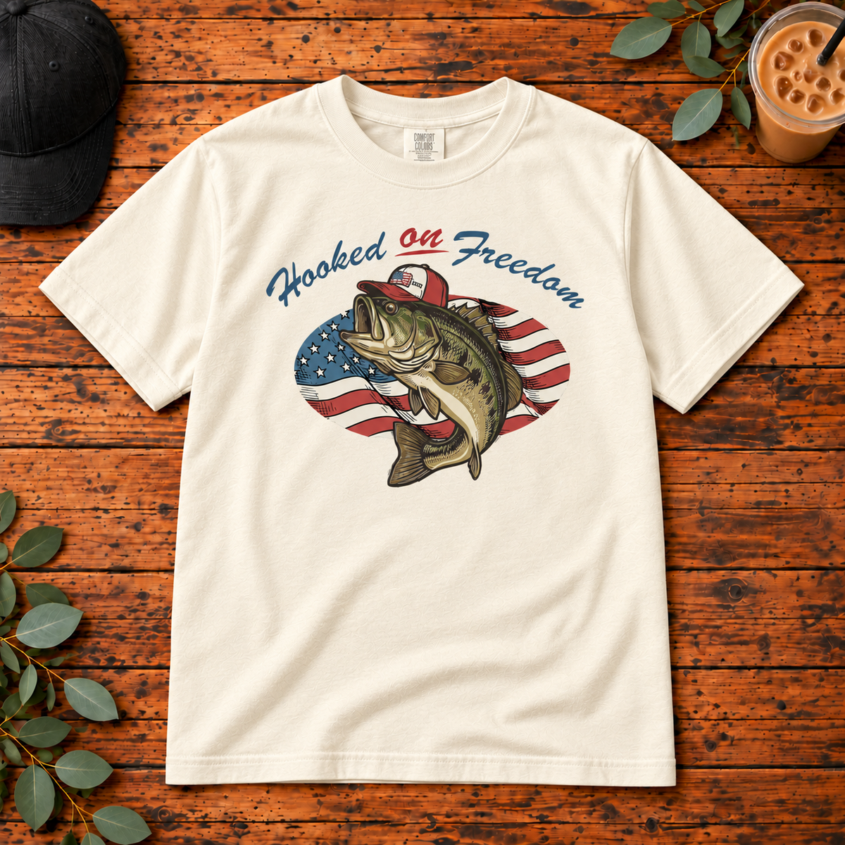 Hooked on Freedom on Comfort Colors Adult Tee — Ivory — single garment on rustic wood