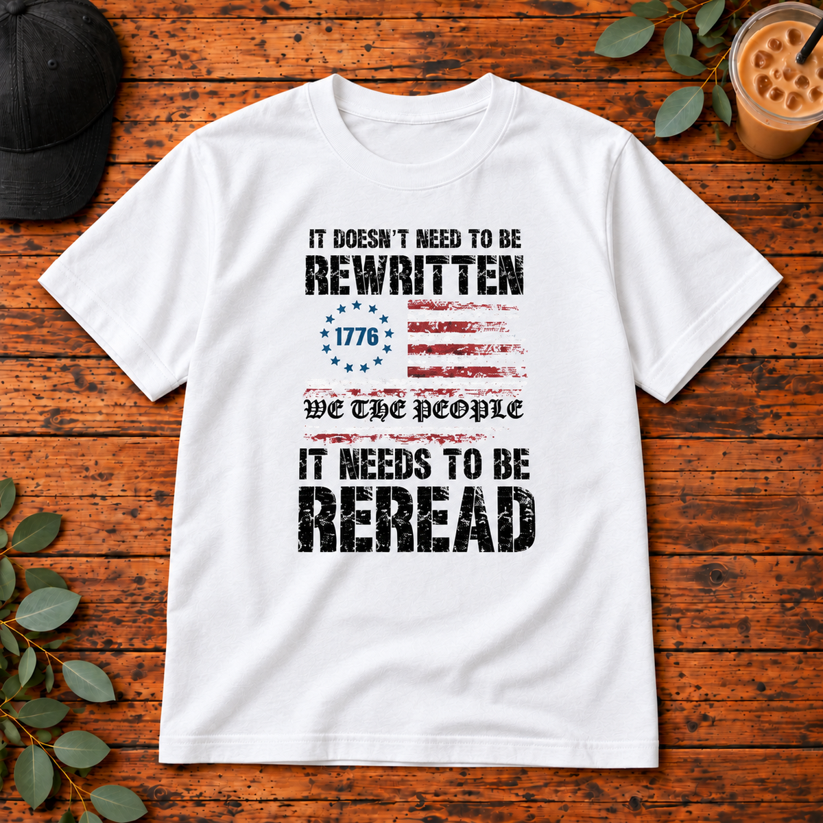We the People It Needs to Be Reread on Gildan Softstyle Adult Tee — White — single garment on rustic wood
