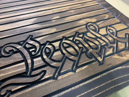 a close up of a wooden bench with graffiti on it